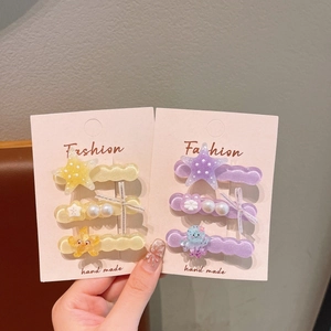 Detailed view of ocean theme starfish and octopus hair clips in yellow and purple sets