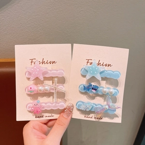 Detail of octopus and starfish jelly color hair clips with pearls on a pink display card