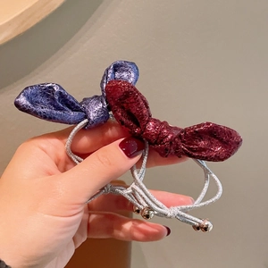 Dettaglio di elastici per capelli blu e rossi metallizzati con perline d'argento