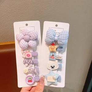 Dettaglio di set di fermagli per capelli con fiori e fiocchi viola e blu per bambini