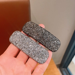 Makroaufnahme von geometrischen Strass-Haarklammern mit schimmerndem quadratischem Design