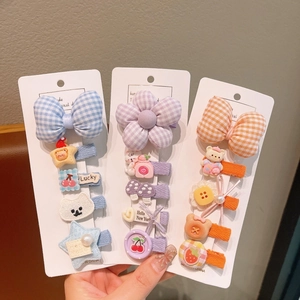 Dettaglio di fermagli per capelli color macaron con fiocchi in tessuto e fiori in resina