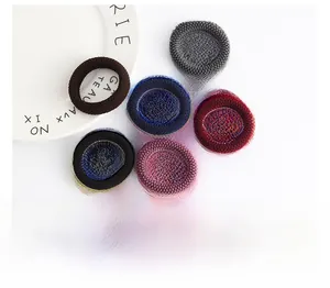 Detailed view of six thick elastic hair ties in assorted colors on a white background