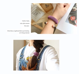 Close-up of purple knitted elastic hair tie worn on wrist and braided hair detail