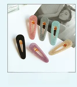 Detailed view of six colorful glitter snap hair clips arranged in a fan shape set