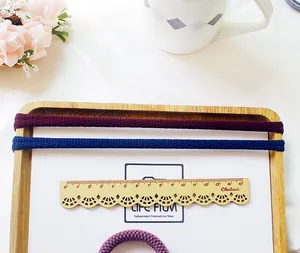 Macro shot of durable elastic hair ties with fine knitted mesh texture on a wooden tray