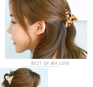 Detail of triangle acetate hair claw clip with marble texture on brunette hair