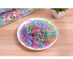 Close-up of bulk colorful disposable elastic rubber hair bands in various macaron colors