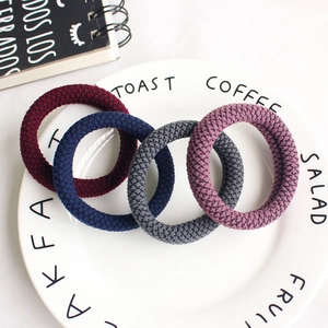 Thick high-elasticity knitted hair ties in burgundy and navy on white ceramic plate