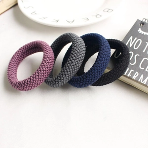 Durable high elasticity hair ties in four colors on a white ceramic plate setting