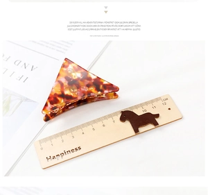 Detail of red-brown acetate hair claw clip with triangle marble texture and smooth edges