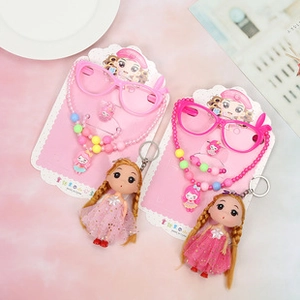 Détail à plat d'un collier de poupée rose avec perles et lunettes de soleil jouets