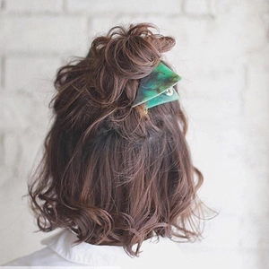 Green marble acetate triangle hair claw clip for women shown on wavy hair