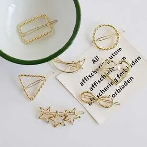 Detail view of various golden geometric hair clips including star and heart shapes