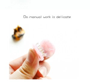 Detail view of mini pink acetate cat hair claw clip with a durable gold metal spring