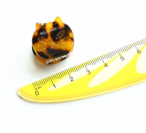 Macro shot of 2.5cm mini tortoiseshell cat hair claw clip on a measurement scale