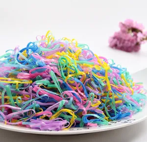 Macro view of colorful high-elastic disposable hair rubber bands in a white ceramic dish