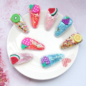 Détail de 8 barrettes pour filles avec paillettes colorées et motifs de fruits en silicone