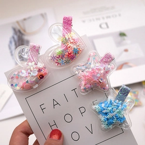 Détail de barrettes à cheveux en forme de cœur et d'étoile avec paillettes colorées
