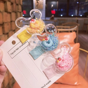 Détail de trois barrettes à paillettes en forme de Mickey avec garnitures colorées