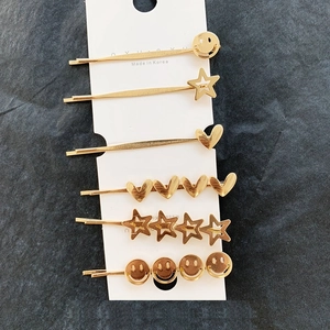 Set of six gold-plated metal hair pins including heart, star, and smiley face designs