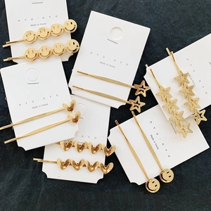 Detailed set of gold alloy hair clips with smiley faces, stars, and heart shapes
