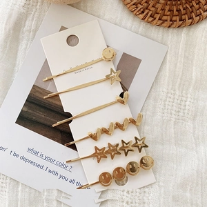 6-piece gold alloy hair clip set with hearts stars and smiley faces on display card