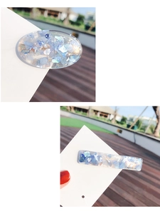 Detail of shell hair clips with blue iridescent flakes in transparent resin material