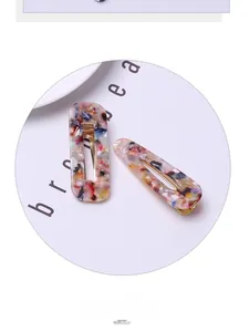 Detail of tortoiseshell patterned acrylic hair clips with golden metal duckbill base
