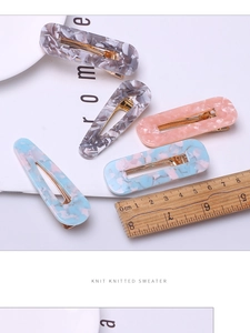 Detailed macro view of 8cm marble texture acetate hair clips with golden metal base