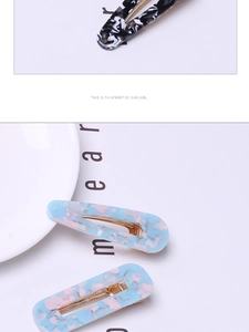 Detailed view of acetate hair clip set with marble and mosaic patterns on gold metal clips