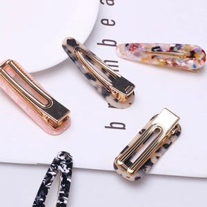 Detailed view of assorted leopard and marble print acetate hair clips with gold bases