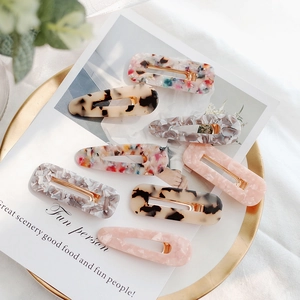 8-piece set of acetate hair clips with leopard print and marble patterns on a gold tray