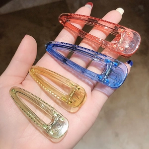 Gros plan d'un lot de 4 pinces à cheveux en acrylique transparent coloré