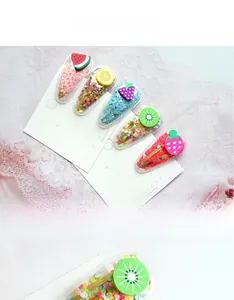 Détail de lot de 5 barrettes fruits avec paillettes colorées et finition PVC transparent