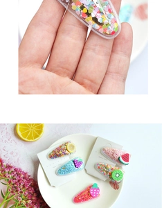 Détail de barrettes transparentes pour enfants avec paillettes colorées et fruits