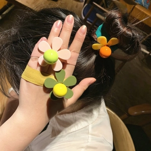 Detail of matte flower hair tie with colorful center bead and elastic woven band