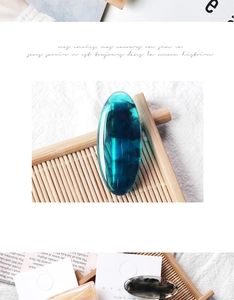 Detailed macro view of the deep blue translucent resin hair clip on a bamboo mat