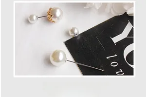 Macro shot of double-pearl earrings with vintage gold crown base and glossy finish