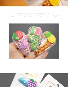 Close-up of glitter-filled acrylic fruit hair clips with strawberry and cherry charms