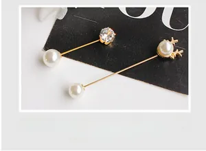 Detail of elegant gold stag antler and crystal pearl brooches for women carded on paper
