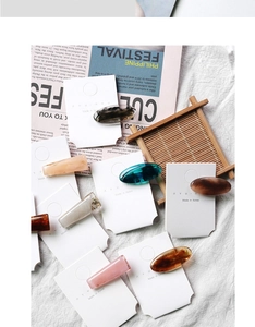 Close-up of retro Korean acetate hair clips with amber and marble patterns on white cards