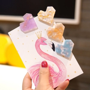 Set of four colorful marble pattern heart hair clips on decorative display card