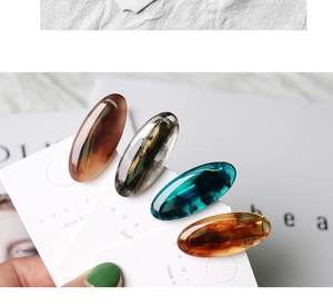Close-up of four colorful marbled resin hair clips on a white display card