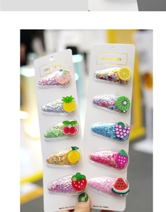 Macro detail of colorful fruit hair clips featuring glitter sequins and acrylic ornaments