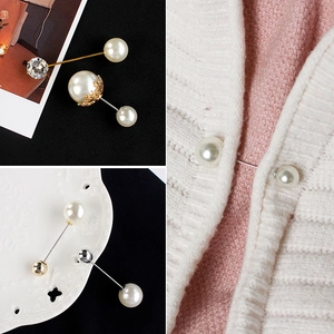 Detail of elegant pearl brooch pins with rhinestones on a knitted cardigan