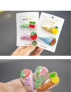 Detail of fruit-themed sequin hair clips with strawberry and lemon shapes for girls