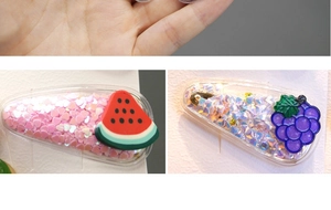 Detailed close-up of transparent hair clips with colorful sequins and fruit patterns