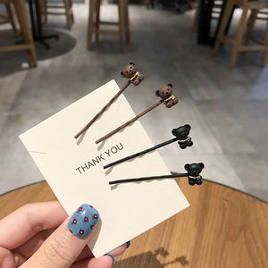 Détail de quatre jolies barrettes ours en marron et noir sur une carte blanche