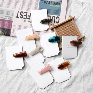 Retro Korean style acetate hair clips in assorted colors on elegant white fabric